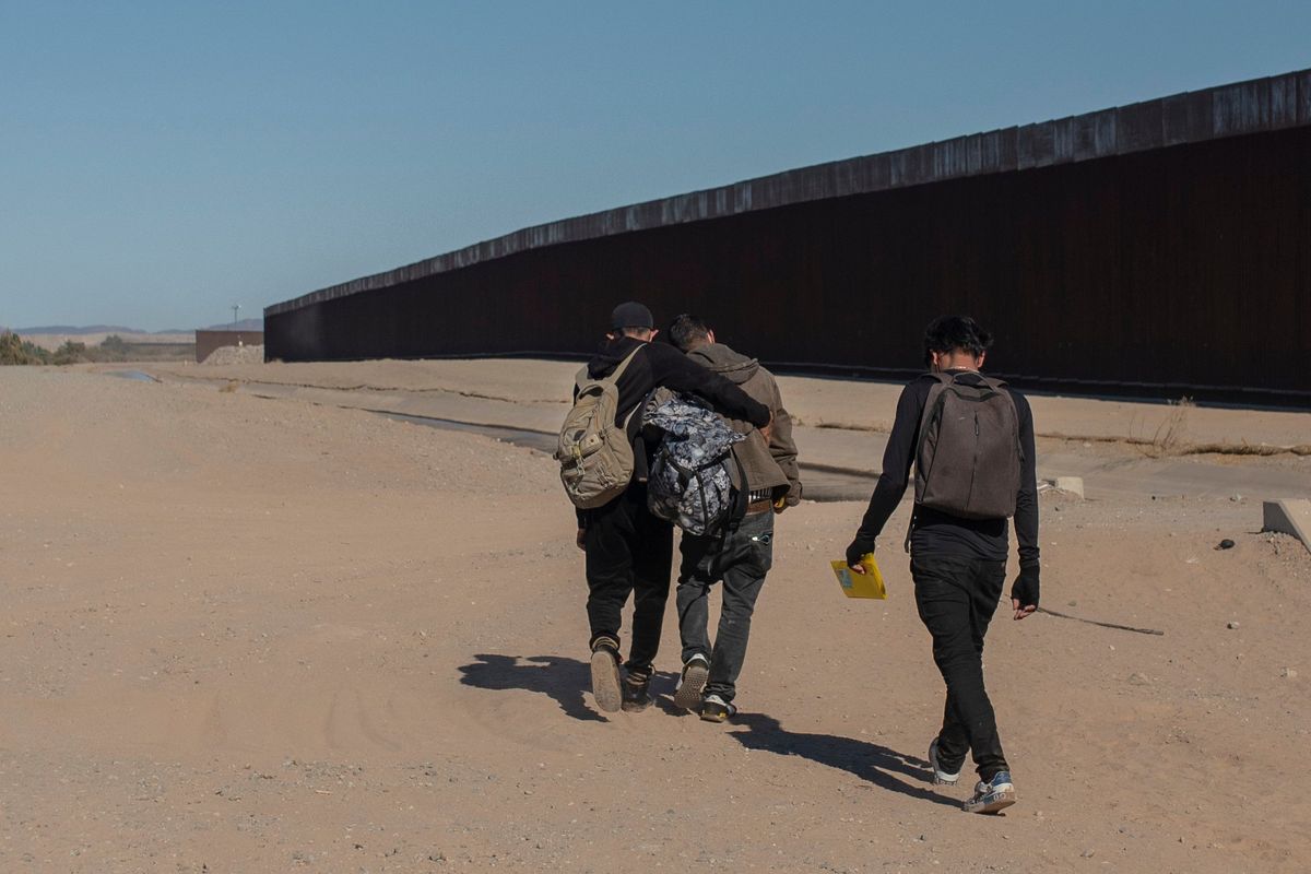 FILE - Nicaraguan migrants walk on the US-Mexico border, in Algodones, Baja California, Mexico, Dec. 2, 2021. The group walked into the U.S. and turned themselves over to the border patrol asking for asylum. The Biden administration has a draft plan to end sweeping asylum limits at the U.S.-Mexico border by May 23 that were put in place to prevent the spread of COVID-19, according to people familiar with the plans.  (Felix Marquez)