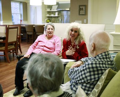 Alexis McKenzie, executive director of an Alzheimer’s assisted-living facility in Washington, D.C., talks with resident Catherine Peake, left, and others on Monday. (Associated Press)