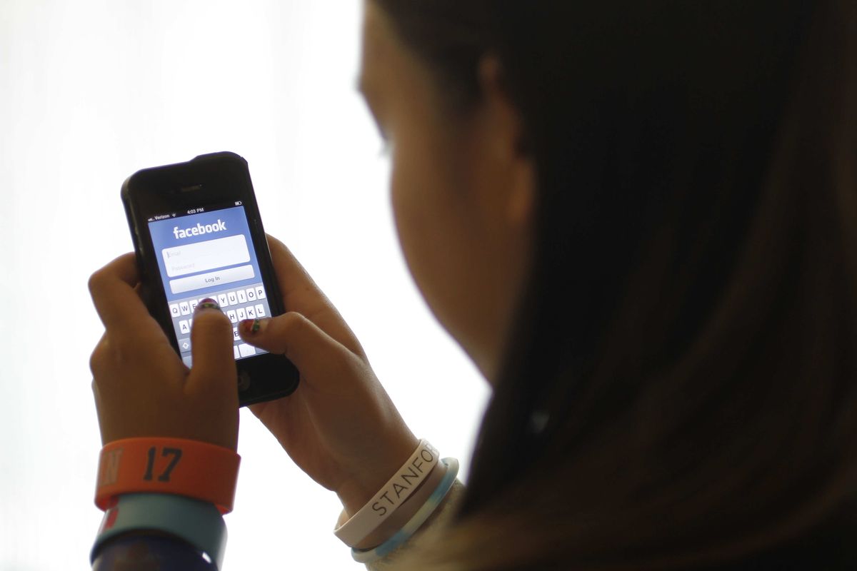 An unidentified 11-year-old girl logs into Facebook on her iPhone in 2012 at her home in Palo Alto, Calif.  (Paul Sakuma)