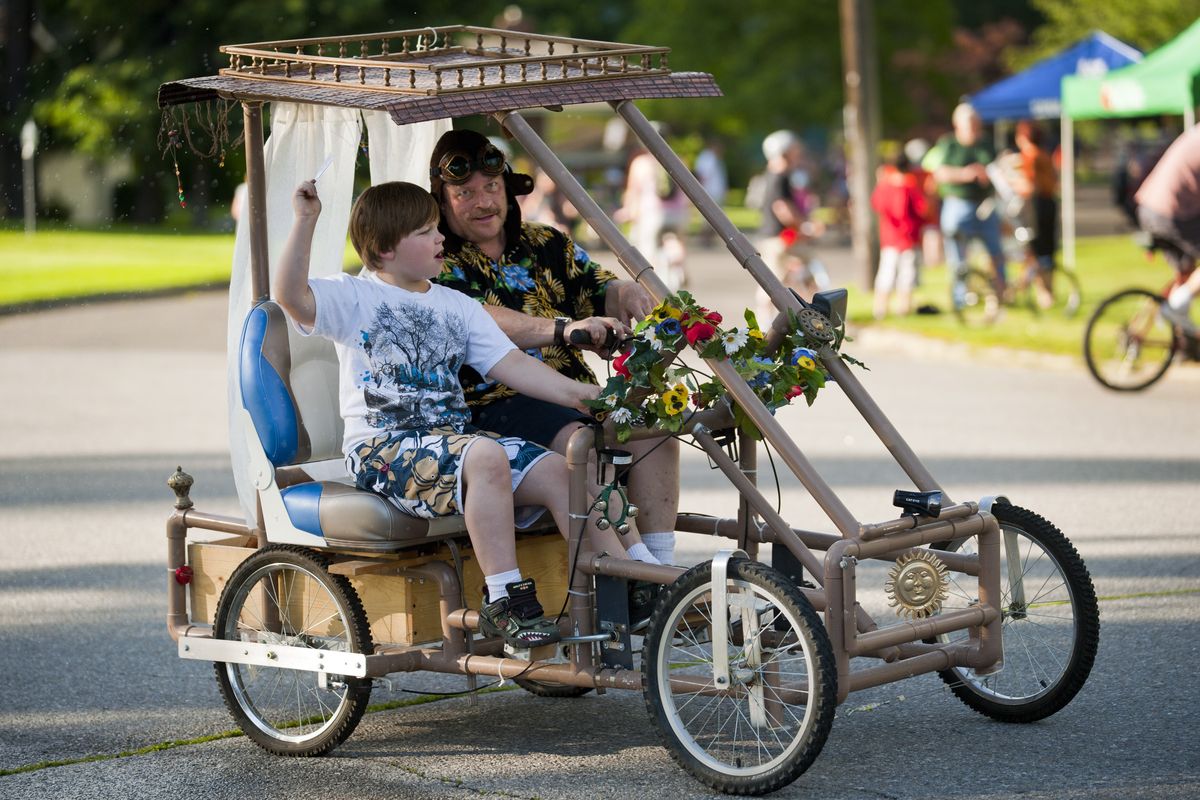 Steven Schneider and grandson Isaac Custer, 7, ride in a hand-built pedal car on Post Street and 30th Avenue during the Spokane Summer Parkways event Wednesday evening. For more photos from the event, go to spokesman.com/photos. (Colin Mulvany)