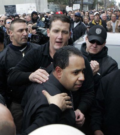 
New Orleans police Officer Robert  Barrios, charged with attempted first-degree murder, is escorted through a crowd of supporters  as he arrives at the city jail in New Orleans on Tuesday. 
 (Associated Press / The Spokesman-Review)