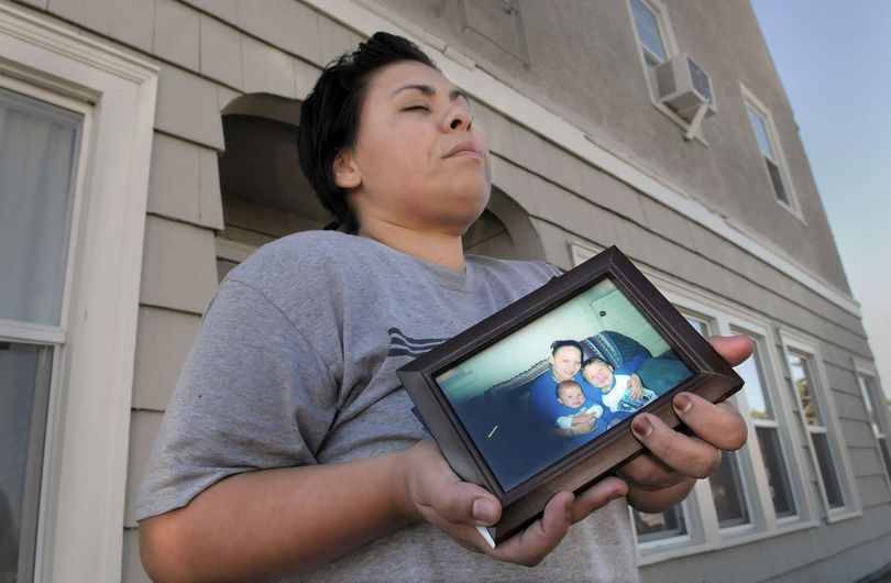 Angela Gilbert struggles to hold back tears as she stands outside a Hillyard apartment building holding a photo of her sister, Rebecca McCollough and her children, Wednesday Sept. 29, 2010. Police say McCollough's 1-year-old son Santiago was beaten to death by her boyfriend Tuesday night. (Christopher Anderson / The Spokesman-Review)