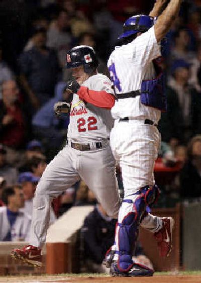 
The Cardinals' David Eckstein scores the first run, getting past Cubs catcher Henry Blanco in the first inning. 
 (Associated Press / The Spokesman-Review)