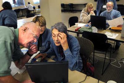 
Volunteer Tom Sylvester teaches volunteers Myriam Munson and Elfrida Mullin a few tricks on the tax program to help people file their taxes during the CASH Coalition's first tax clinic at Numerica Credit Union on Havana Street. The clinic will be offered at the site for two weeks and later at other Spokane area locations. 
 (Rajah Bose / The Spokesman-Review)