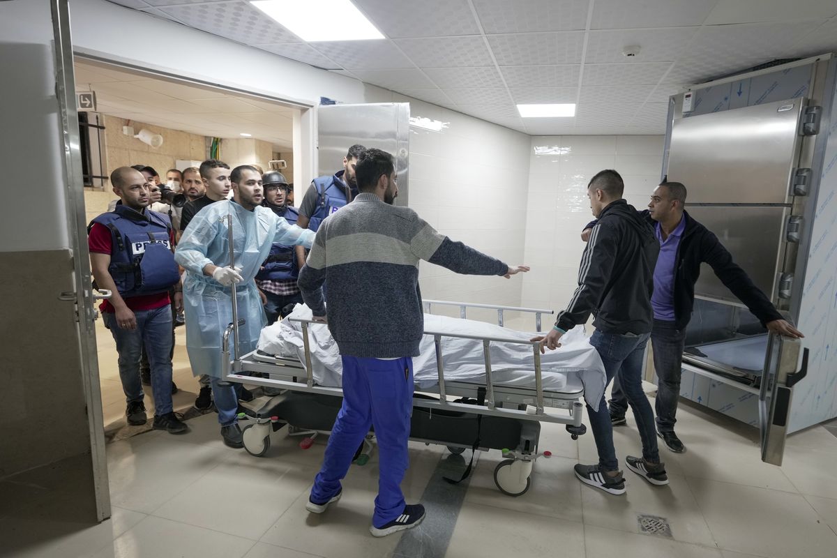 Journalists and medics wheel the body of Shireen Abu Akleh, a journalist for Al Jazeera network, into the morgue inside the Hospital in the West Bank town of Jenin, Wednesday, May 11, 2022. The well-known Palestinian reporter for the broadcaster