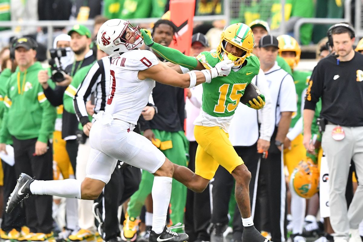 Oregon Ducks wide receiver Tez Johnson (15) grabs the facemask of Washington State Cougars defensive back Sam Lockett III (0) who returns the favor during the second half of a college football game on Saturday, Oct. 21, 2023, at Autzen Stadium in Eugene, Ore. Oregon won the game 38-24.  (Tyler Tjomsland/The Spokesman-Review)