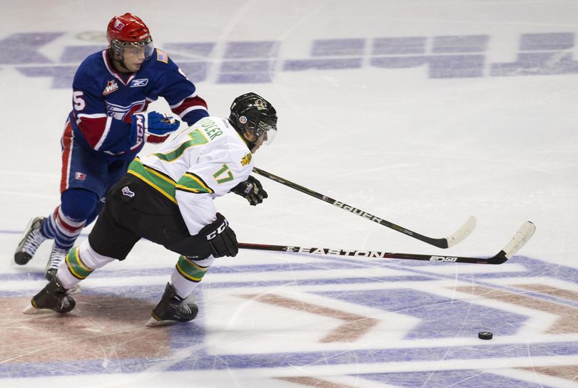 Spokane Chiefs Tanner Mort (5) and Prince Albert's Todd Fiddler chase the puck in the second period, Friday, Oct. 14, 2011, in the Spokane Arena. (Colin Mulvany / The Spokesman-Review)