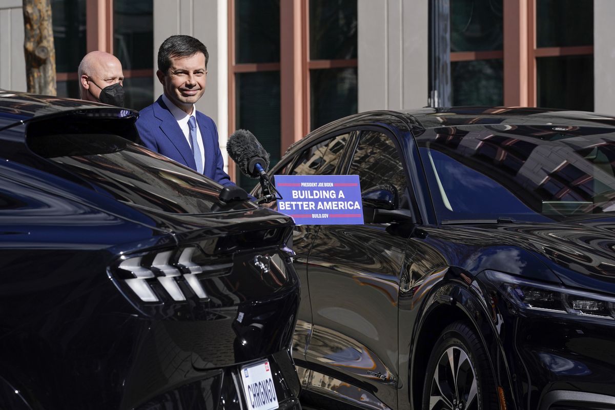 Transportation Secretary Pete Buttigieg, right, speaks during an event at the Transportation Department in Washington, Thursday, Feb. 10, 2022, announcing a historic investment in the U.S. electric vehicle charging networks. White House infrastructure coordinator Mitch Landrieu listens at left. (Susan Walsh)