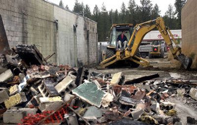 
Brian Schimmels with Red Diamond Construction Inc. clears debris at the site of a burned-out building on the 8700 block of East Sprague  in Spokane Valley on Thursday. The building burned about four years ago. 
 (Liz Kishimoto / The Spokesman-Review)