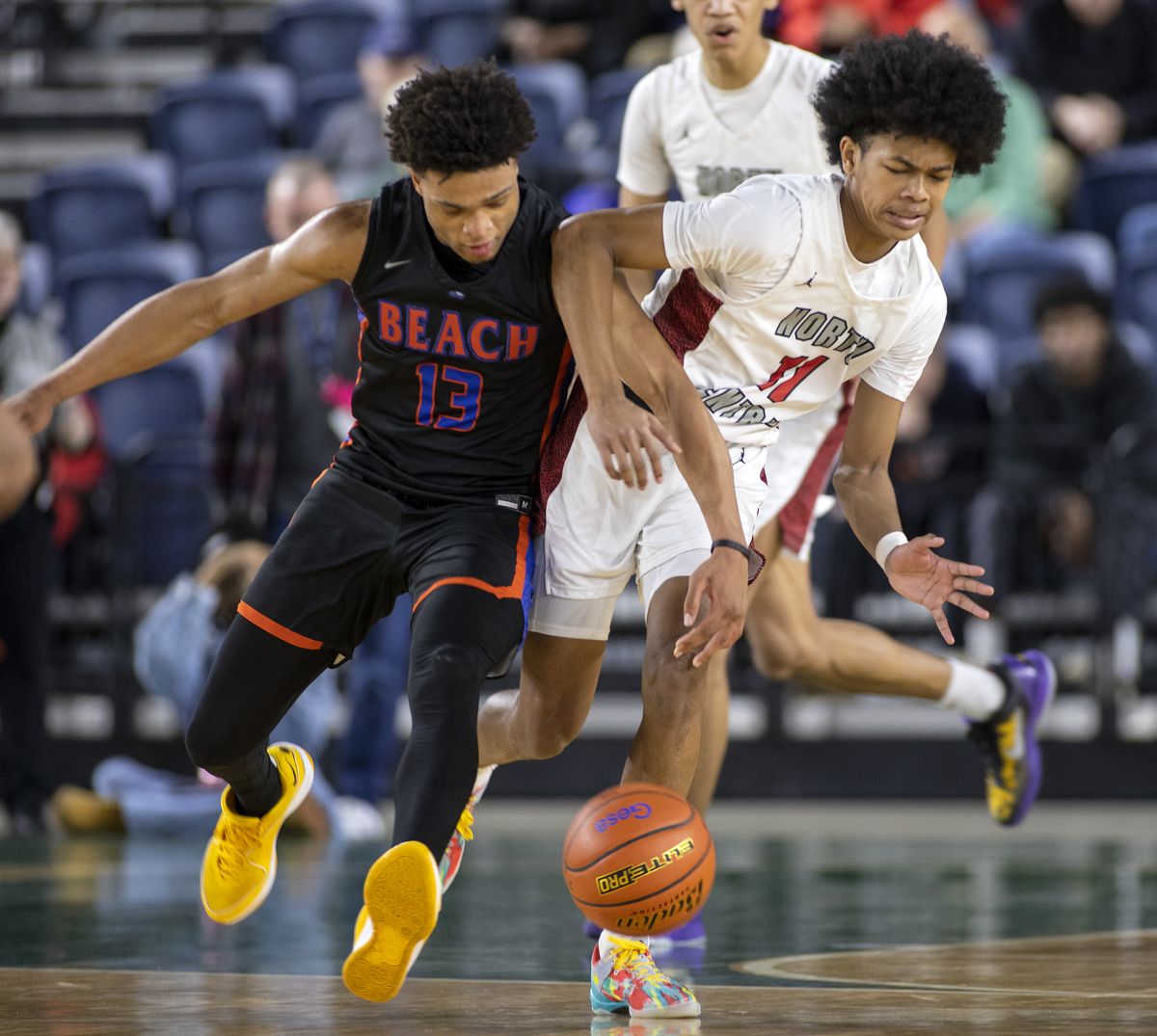 North Central’s Trevelle Jones, right, battles for a loose ball with Rainier Beach’s Maceo Rivers during quarterfinal action Thursday, Feb. 29, 2024, at the 3A State Boys Basketball Tournament in Tacoma, Wash. North Central fell to Rainier Beach 64-53.  (Patrick Hagerty)