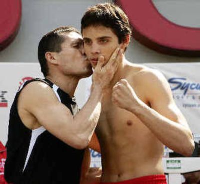 
Both scheduled to fight tonight, Julio Cesar Chavez, left, kisses his son Julio Jr. on the cheek during Friday's weigh-in at Staples Center. 
 (Associated Press / The Spokesman-Review)