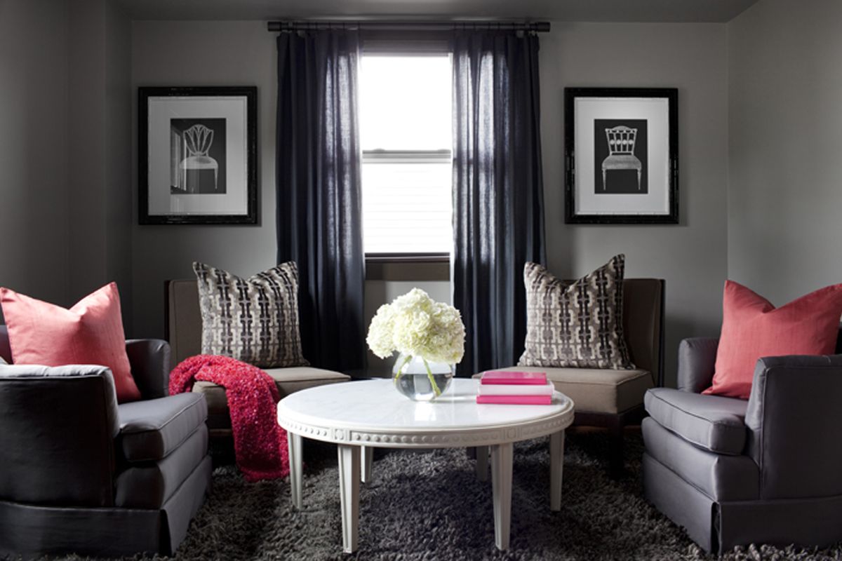 In this lounge space for a husband and wife, designer Brian Patrick Flynn used a neutral gray backdrop then mixed in her pink pillows and throw blanket with his brown area rug and club chairs.