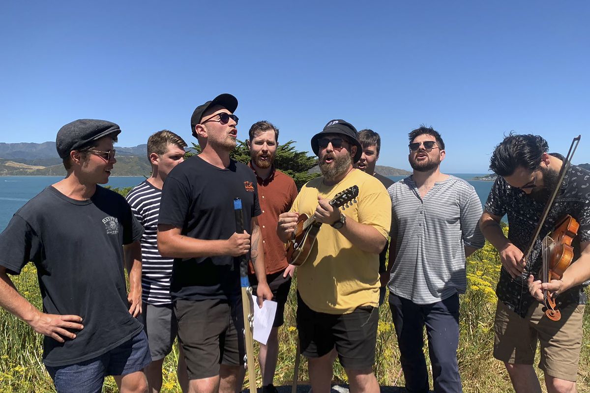 Martin Powell, from left, Daniel Millar, Tom Cumming, Pete Bowman, Ben Bamford, Cameron Langdon, Will Wragg and James Carroll from the band the Salty Wailers perform a sea shanty on Wednesday, Jan. 31, 2021 in Wellington, New Zealand. The Salty Wailers started singing together a year ago as an “excuse to go for a pint on a weeknight,” performing in pubs across Wellington.  (Nick Perry)