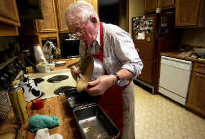 
Melvin LeShaw pours his zucchini bread mixture into two pans in his Rockford home on Wednesday. 
 (Liz Kishimoto / The Spokesman-Review)
