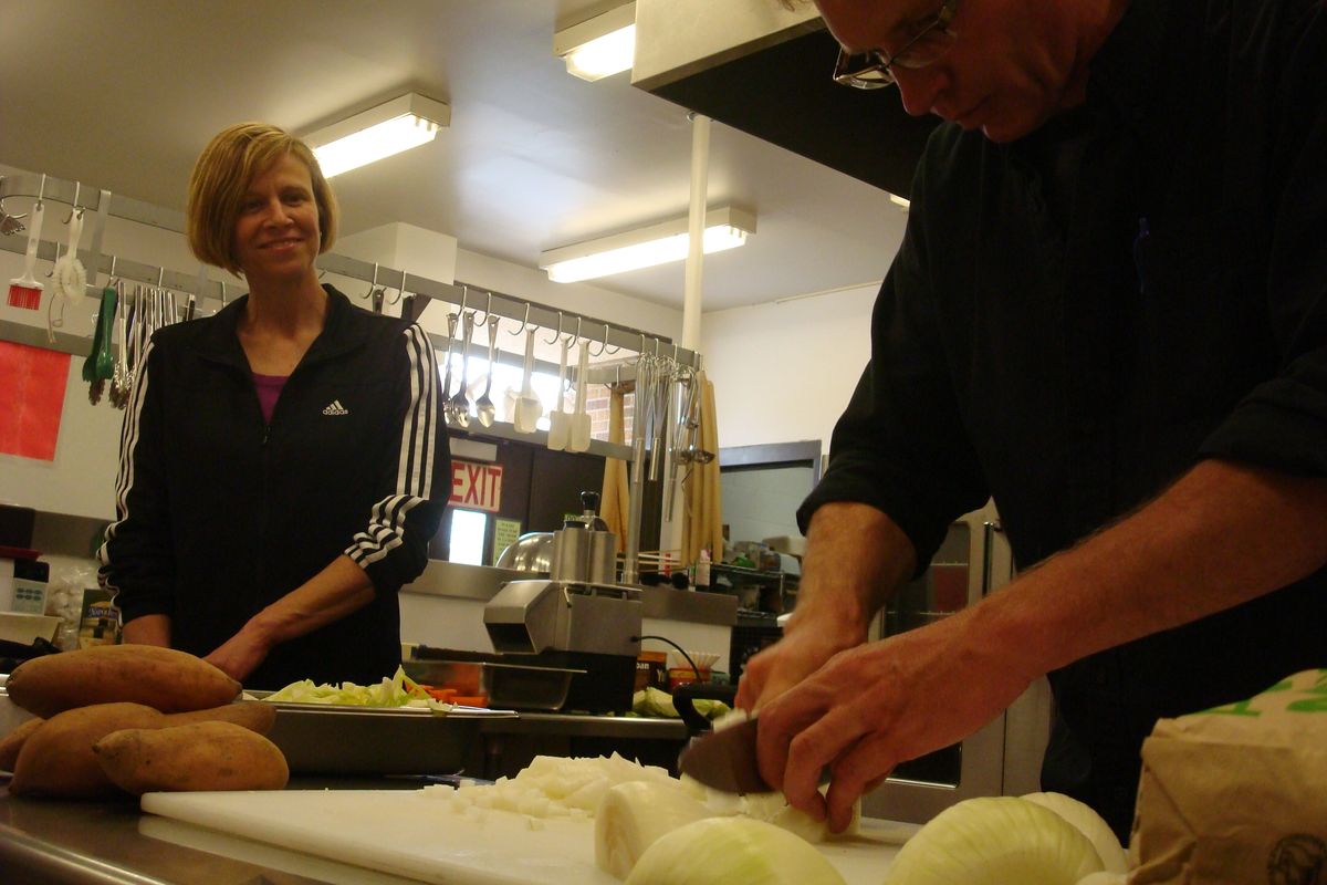 Raeann Ducar, left, nutrition services director of the Freman School District, watches Kent Getzin prepare vegetables during a visit to area schools and farms with the goal of offering locally grown items to students.  (Shallan Knowles / Down to Earth NW Correspondent)