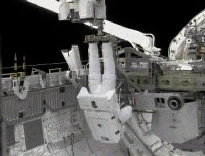 
In this image from NASA TV, space shuttle Discovery Mission Specialist Steve Robinson can be seen suspended from Discovery's robotic arm during a space walk Saturday. 
 (Associated Press / The Spokesman-Review)
