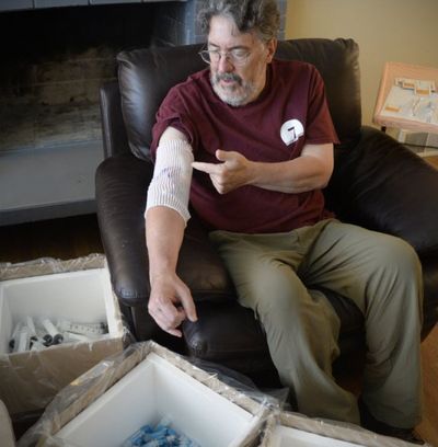 Paul Turner, Slice columnist at The Spokesman-Review, talks about his course of treatment through a port placed in his arm and surrounded by some of the medical supplies used in his recovery from a rare brain infection that mimicked the symptoms of a stroke and has kept him away from work as he receives dose after dose of powerful antibiotics during his recovery. Photographed at home Monday, Aug. 3. (SR photo: Jesse Tinsley)
