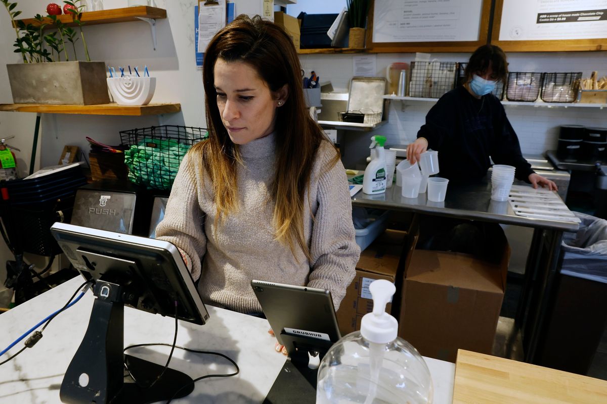 Deena Jalal, owner of plant-based ice cream chain FoMu, works behind the counter in her shop on Tremont Street, Friday, Jan 14, 2022, in Boston.  (Michael Dwyer)