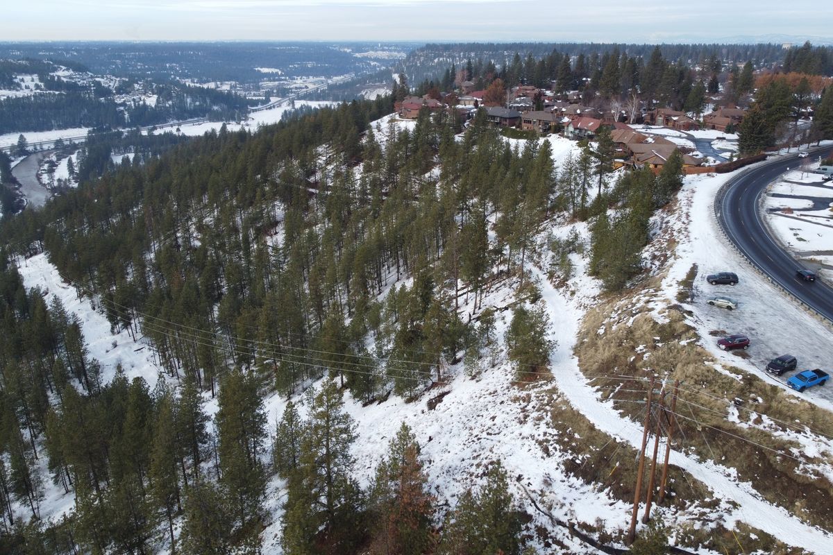 The hillside parcel of land below Hatch Road, seen at right, is going up for auction and may sell to a new owner who would go ahead with a development plan already in place for condos, called Tuscan Ridge. The undeveloped parcel, shown Thursday, gets heavy use by bikers and hikers who park along Hatch Road, far right, and access the trail along the bluff. The development in the upper right of the photo is Quail Ridge.  (Jesse Tinsley/THE SPOKESMAN-REVIEW)