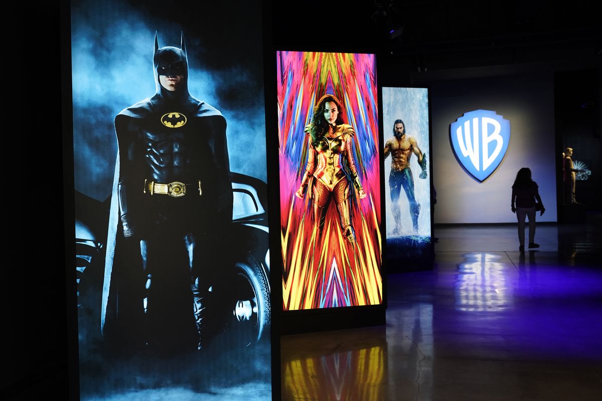 A visitor walks past portraits of DC Comics superheroes as she enters the “Action and Magic Made Here” interactive experience at the Warner Bros. Studio Tour Hollywood preview June 24 in Burbank, Calif.  (Chris Pizzello/Invision/AP)