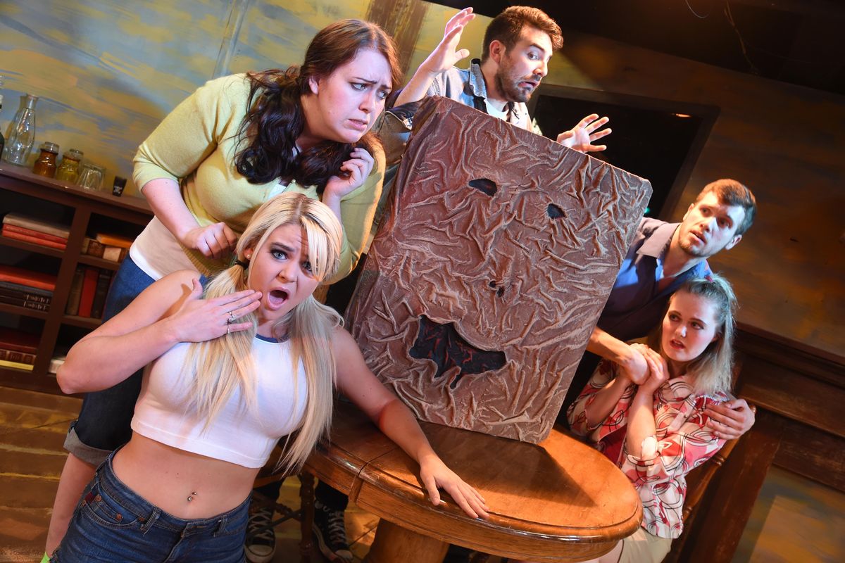 The cast of Spokane Civic Theatre’s “Evil Dead: The Musical,” from left, Tanya Barton, Whitney Huskey, Alexander Edmonds, Martin Sanks and Talena Kelln, gather around the Necronomicon, or book of the dead, they’ve found in a remote cabin in the play based on the campy horror movie series. Sanks plays Ash, the dubious hero. (JESSE TINSLEY jesset@spokesman.com)