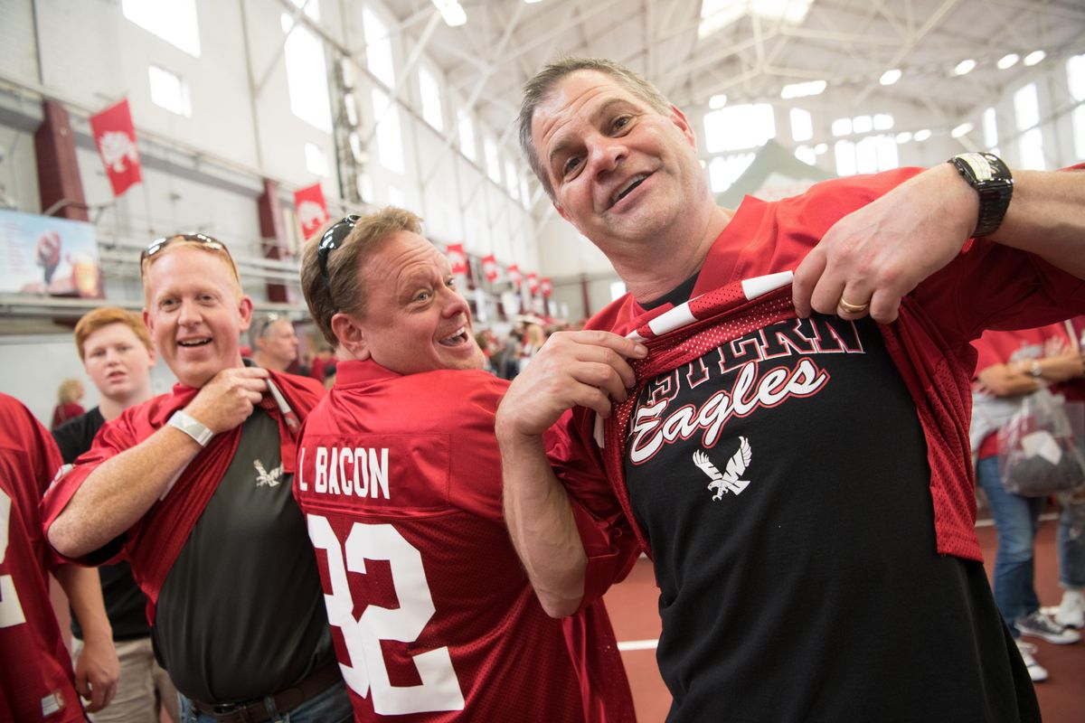 Kent Bacon, right, uncle to Washington State Cougars wide receiver Lucas Bacon (82), and an EWU alum, poses for the camera showing he wore his true colors under a jersey supporting his nephew, along with fellow EWU alum Gary Wilson, right, and family friend Dan Garske, center before the first half of a college football game between WSU and Eastern on Saturday, September 15, 2018, at Martin Stadium in Pullman, Wash. (Tyler Tjomsland / The Spokesman-Review)