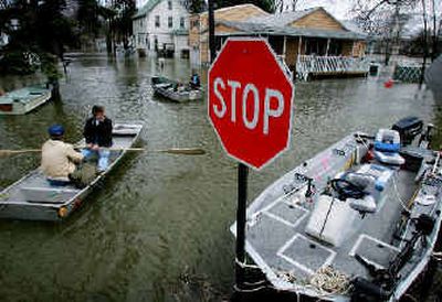 
Residents of Wayne, N.J., who live on a road that borders the Passaic River, take to their boats Monday. Threatening weather including heavy rainfall and snow hit three East Coast states with a powerful punch.
 (Associated Press / The Spokesman-Review)
