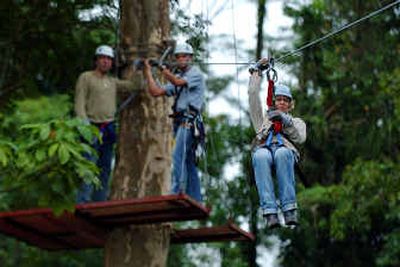 
Dutch tourist Carolyn Dorsman rides through the canopy of the tropical forest as her husband Wim Dorsman, far left, and Costa Rican guide Esteban Cedeno, center, look on at the Arenal Volcano near La Fortuna, Costa Rica.
 (Associated Press / The Spokesman-Review)