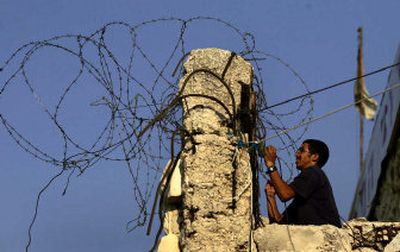 
A Jewish settler sets up barbed wire Monday at an old British fortress in the Jewish settlement of Sanur in the West Bank. 
 (Associated Press / The Spokesman-Review)