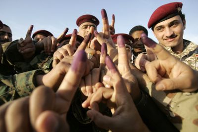 Iraqi soldiers display their ink-stained fingers after casting their votes Wednesday in Najaf, Iraq.  (Associated Press / The Spokesman-Review)