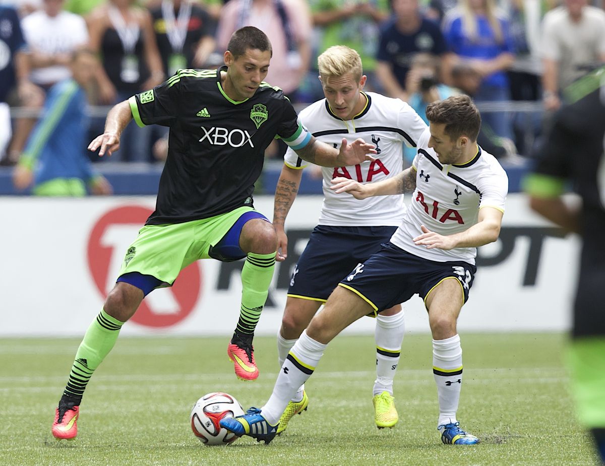 Seattle’s Clint Dempsey, left, battles Tottenham Hotspur