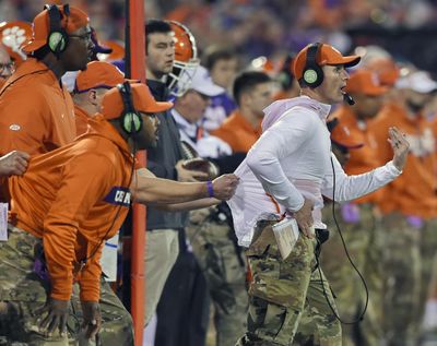 In this Nov. 17, 2018 photo, Clemson defensive coach Brent Venables is pulled back by an assistant during the first half of an NCAA college football game in Clemson, S.C. Clemson’s defense was a big reason why the Tigers won a second national championship in three seasons. Now that unit has massive holes to fill after losing its entire front to the NFL, along with three key linebackers and two members of the secondary – and that could mean the Tigers have to win shootouts behind quarterback Trevor Lawrence to stay on top. (Richard Shiro / Associated Press)