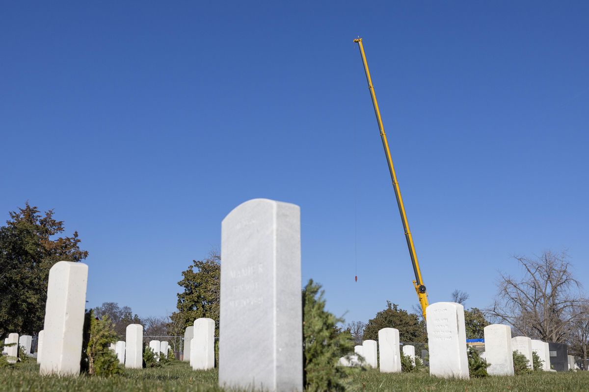 A crane for the statue removal looms over graves at Arlington National Cemetery. MUST CREDIT: Amanda Andrade-Rhoades for The Washington Post  (Amanda Andrade-Rhoades/For The Washington Post)