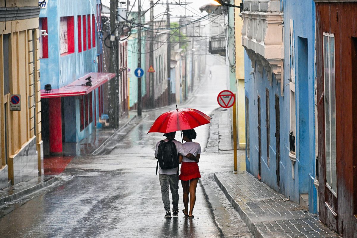 A couple walks in a street before Hurricane Melissa hits the city of Santiago de Cuba, Cuba, on October 28, 2025. (Yamil Lage/AFP/Getty Images/TNS)  (Yamil Lage/Getty Images North America/TNS)