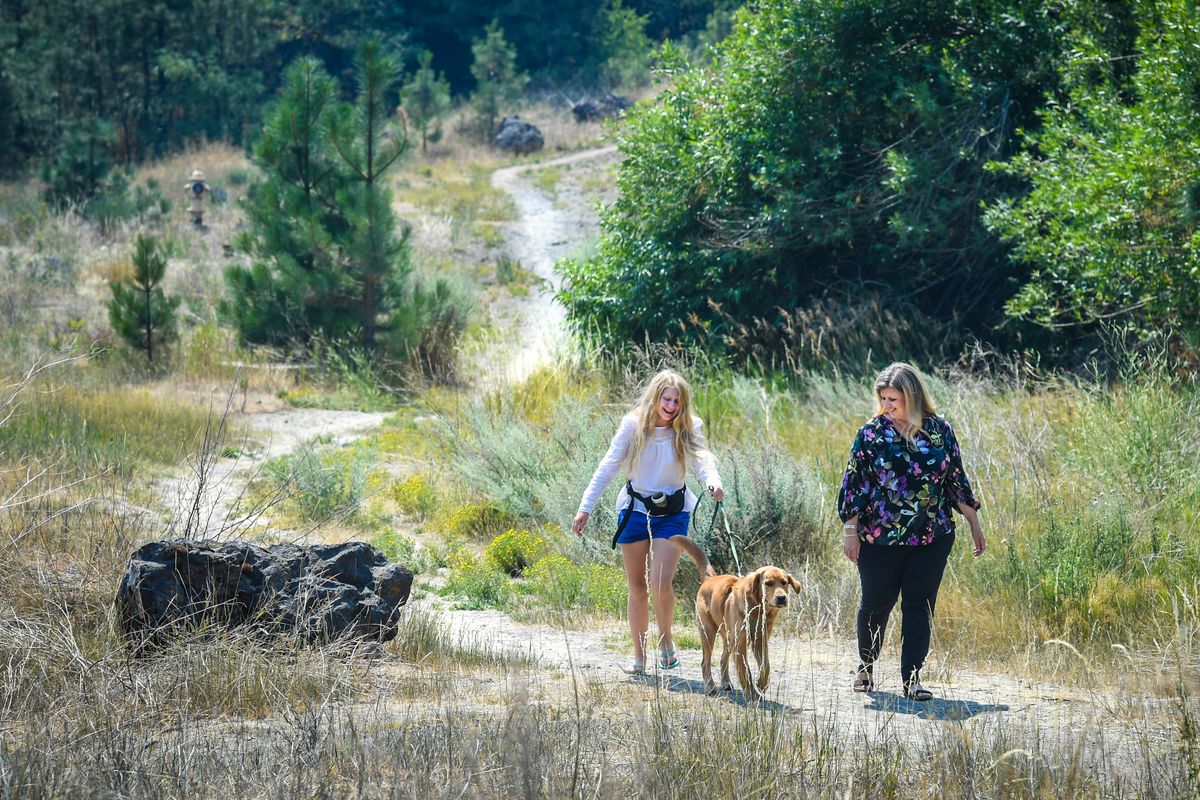 Joy Sheikh, right, along with her daughter, Laura, and dog Archie, walk through the Grandview neighborhood on Friday. Sheikh is opposed to a plan for a new development called Westwood Hills because she’s concerned about traffic and impacts to wildlife.  (Dan Pelle/The Spokesman-Review)
