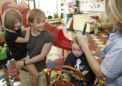 
Mary Ann Ray, left, holds her daughter Marisa, 5, as her son Ethan, 2, gets a haircut by stylist Bev Sears at Cookie Cutters children's hair salon last week in Batavia, Ohio. While rising prices at the gas pumps have gotten the most attention, increases are also pulling at pocketbooks from a variety of directions. 
 (Associated Press / The Spokesman-Review)