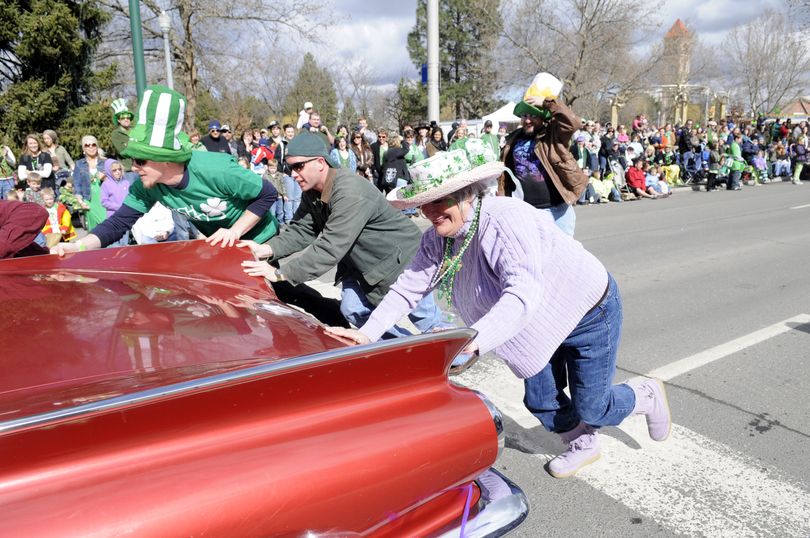 Shanna Michel, center, piles out of Carol Yamamoto's 1960 Buick to help push it in the St. Patrick's Day parade Saturday, Mar. 13, 2010 in downtown Spokane.  The car was carrying members of the 