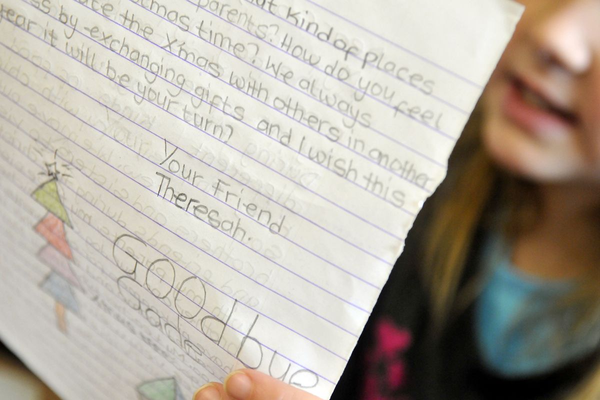 Adams Elementary third-grader Jade Leinwebber reads a pen pal letter from a schoolgirl in Ghana named Theresah.