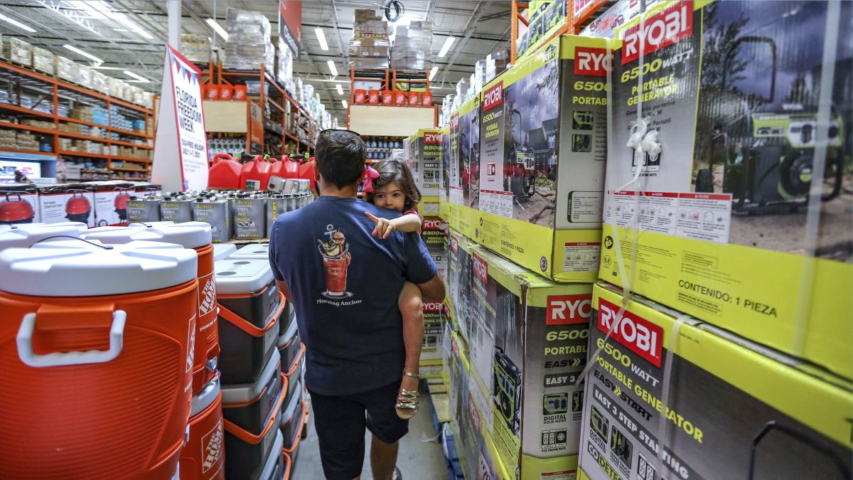Frank Barakat carries his daughter Valentina, 2, through an shopping aisle dedicated for hurricane supplies as the Home Depot store prepares for possible effects of tropical storm Elsa in Miami on Saturday, July 3, 2021. Elsa fell back to tropical storm force as it brushed past Haiti and the Dominican Republic on Saturday and threatened to unleash flooding and landslides before taking aim at Cuba and Florida.  (Al Diaz)
