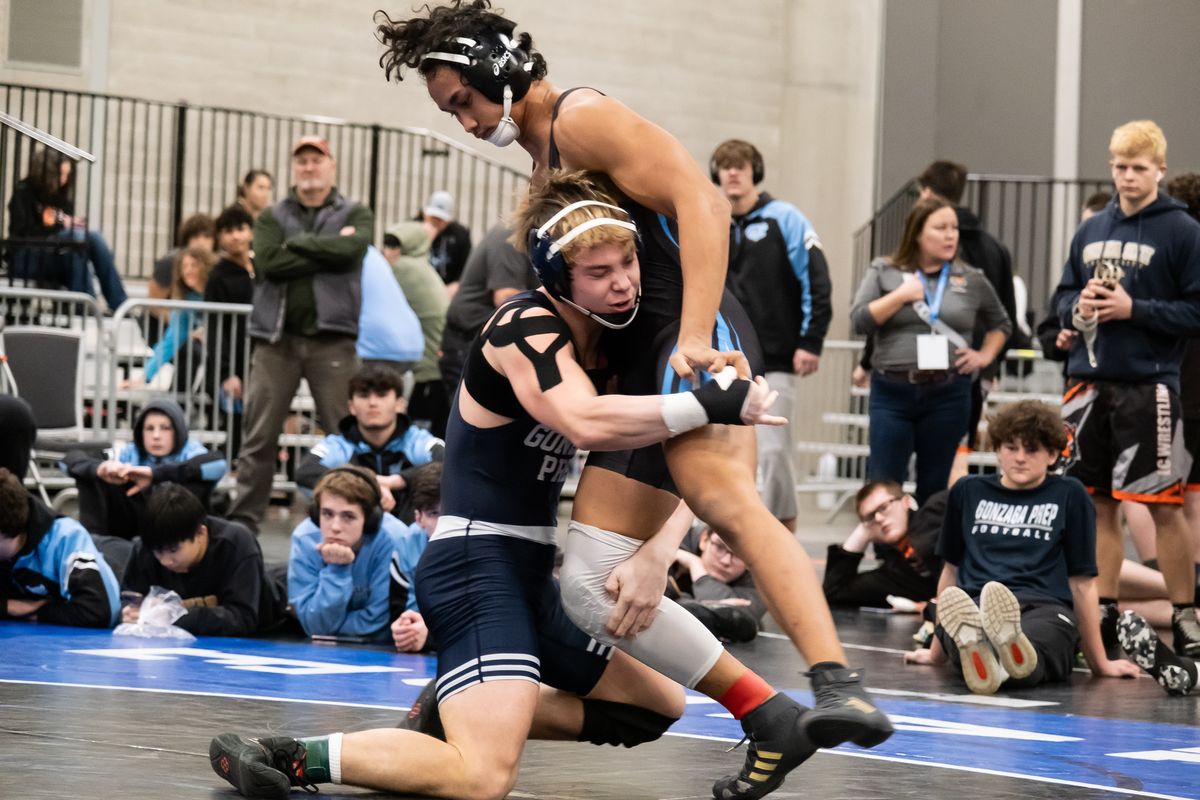 Noah Holman, left, of team champion Gonzaga Prep, goes for a takedown against Central Valley’s Geziah Boui during the District 8 4A wresting tournament Saturday at the Spokane Convention Center.  (Madison McCord/For The Spokesman-Review)