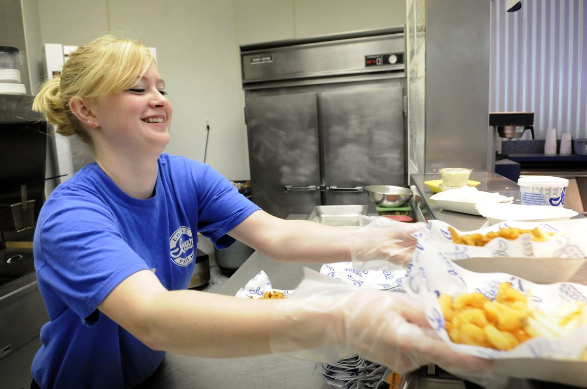 Cook Kayla Lewis serves up fish and chips at Ivar’s Seafood Bar at NorthTown mall Thursday. New federal laws will require restaurants to tell customers about the calorie and fat content of their food. (Jesse Tinsley / The Spokesman-Review)