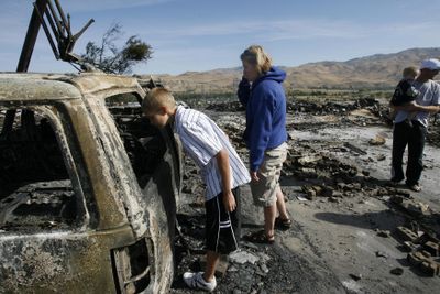 Spencer Lee, 14, inspects the family’s vehicle on Tuesday with his parents, Christopher and Mindy Lee, and  18-month-old brother Adam. Idaho Statesman (Kerry Maloney Idaho Statesman / The Spokesman-Review)