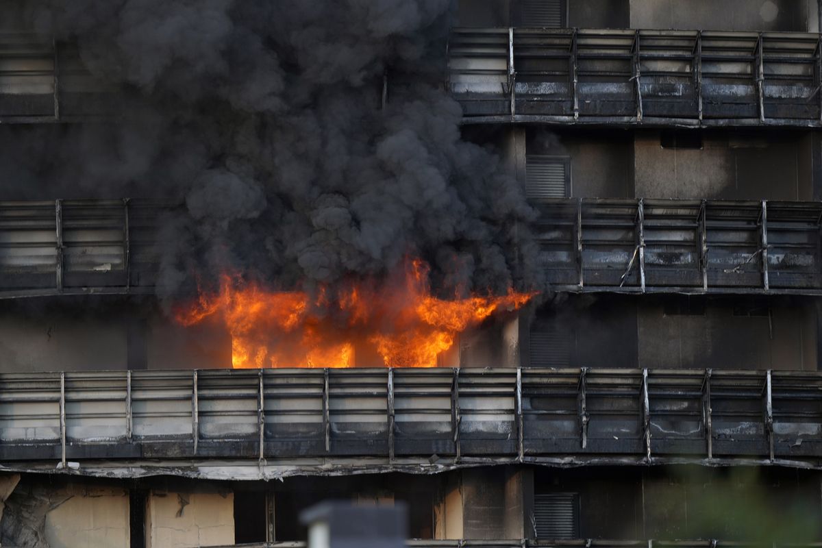 Smoke billows from a building in Milan, Italy, Sunday, Aug. 29, 2021. Firefighters were battling a blaze on Sunday that spread rapidly through a recently restructured 60-meter-high, 16-story residential building in Milan. There were no immediate reports of injuries or deaths.  (Luca Bruno)