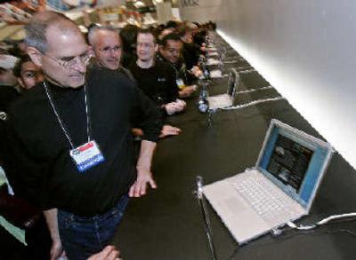 Apple Computer Inc. CEO Steve Jobs looks at a MacBook Pro laptop at the MacWorld conference last month in San Francisco. 
 (Associated Press / The Spokesman-Review)