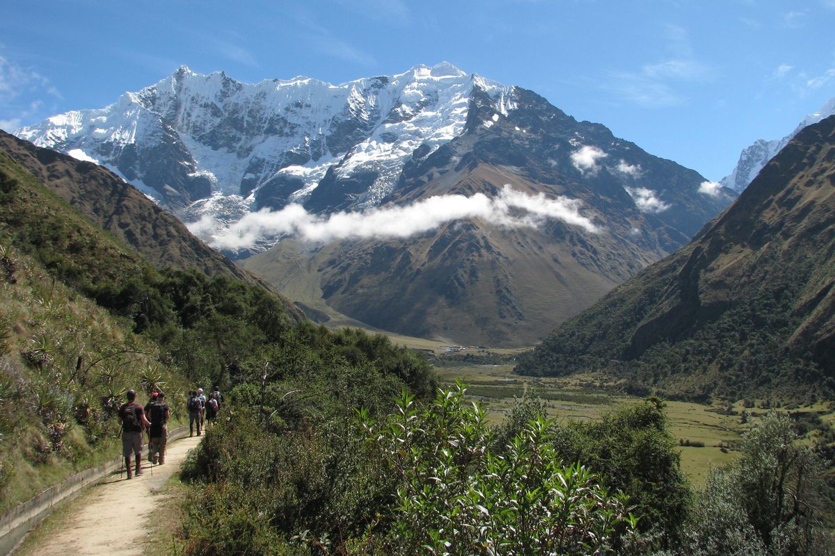 Hikers walk toward Humantay Mountain on the Salkantay Trail, one of the historic Inca trails that lead through the Andes to Machu Picchu. The trail