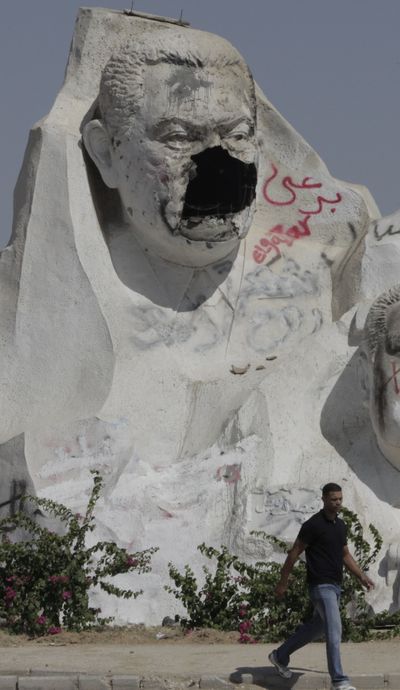 A man walks past a defaced statue of ousted Egyptian President Hosni Mubarak, in 6th of October city, just outside Cairo, Egypt, on Tuesday. (Associated Press)
