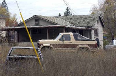 
The residence at  10003 E. 15th sits on an overgrown lot with an abandoned car. 
 (Liz Kishimoto / The Spokesman-Review)