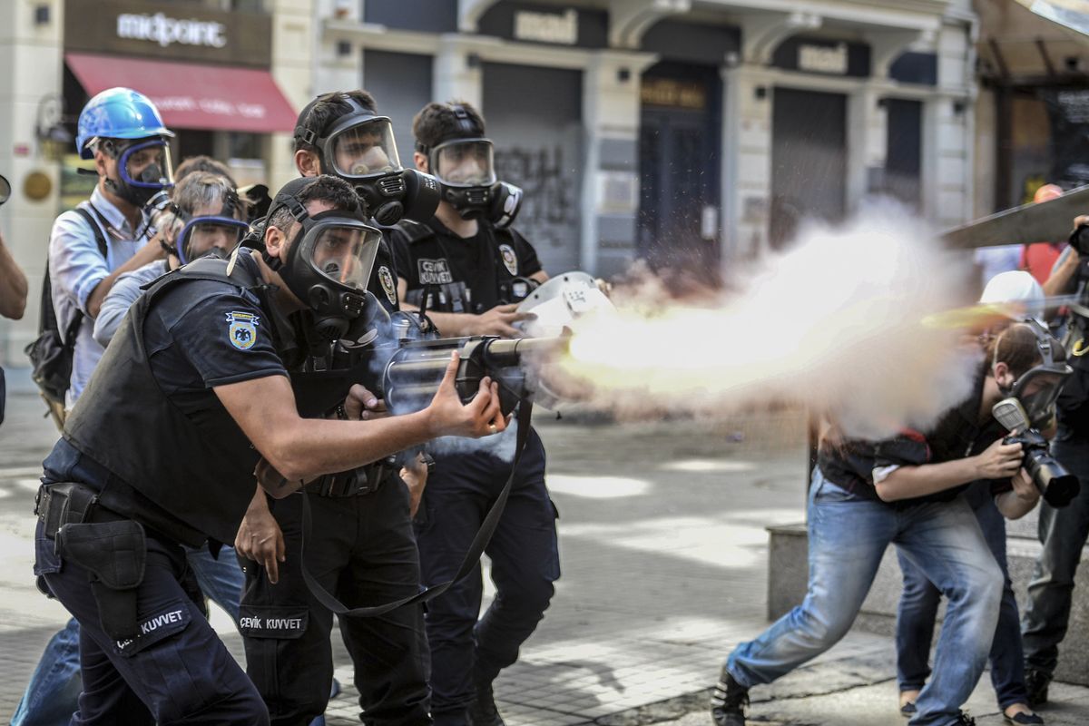 Police fire tear gas as riot police spray a water cannon at demonstrators who remained defiant Sunday after authorities evicted activists from an Istanbul park. (Associated Press)