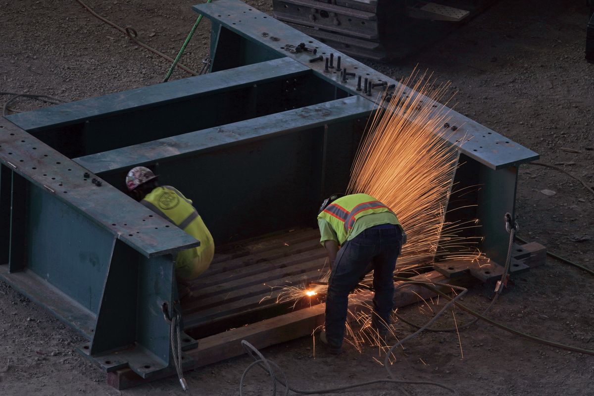 Workers and a shower of sparks are shown as a temporary center support column is dismantled, Tuesday, Sept. 1, 2020, as work continues on the Climate Pledge Arena in Seattle, the home of the Seattle Kraken NHL hockey team. Sometime in the late summer or early fall of 2021, the Kraken will open the new facility – at a cost that will likely total $1 billion by the time it’s done – and become the NHL’s 32nd franchise. (Ted S. Warren)