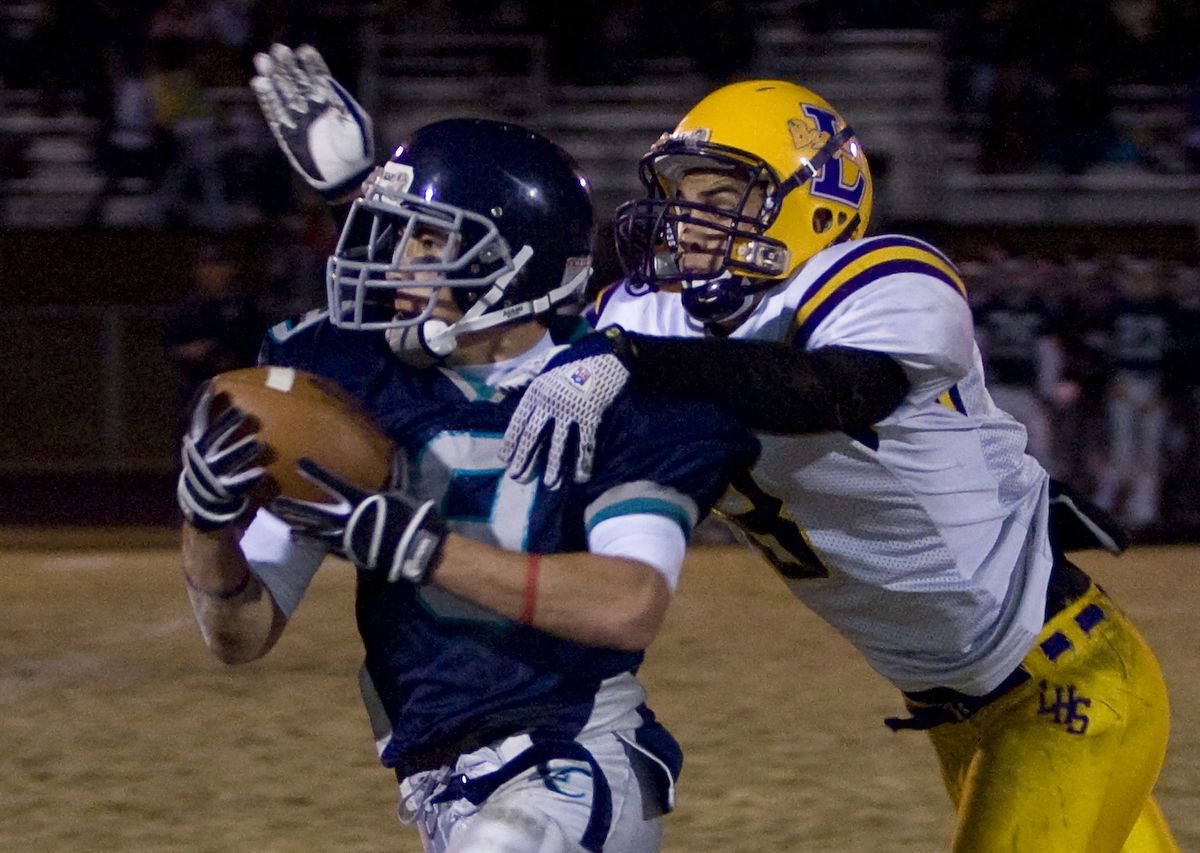 Lake City’s Julian Burgess pulls in a long pass as Lewiston’s Ryan Young pulls him down in the second quarter at Lake City High School. Special to (Bruce Twitchell Special to / The Spokesman-Review)